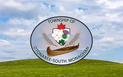 OSM Township logo, sitting on green grass with blue sky above