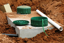 Septic tank in the ground with green lids on top